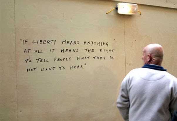 Homme observant un graffiti déclarant le droit à la liberté d'expression