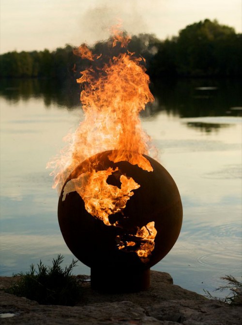 Boule de métal embrasée crachant les flammes au bord d'un lac